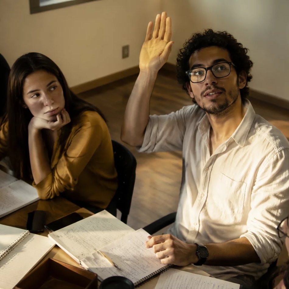 Roda de participantes; um deles repete em voz alta o argumento do colega antes de dar a resposta